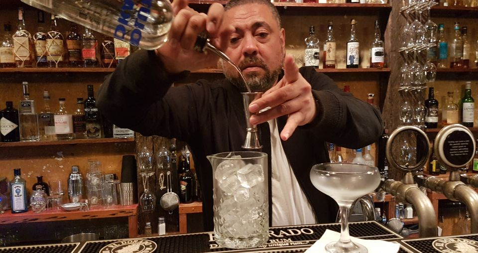 Poni Sula pouring a measure behind the bar